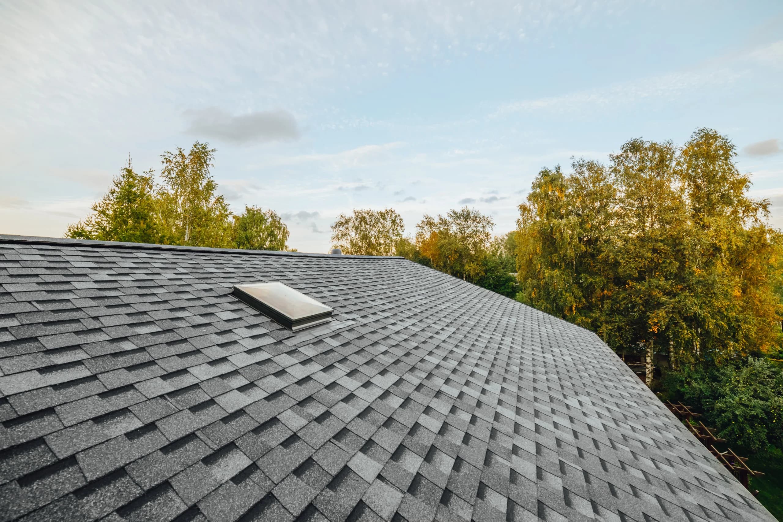 Completed asphalt shingle roof on a home at golden hour